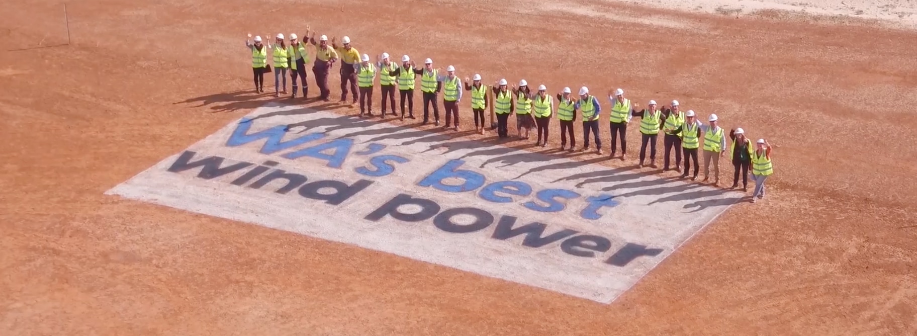 An image of several young schoolchildren in a school setting pictured with an Alinta Energy employee and two community workers.